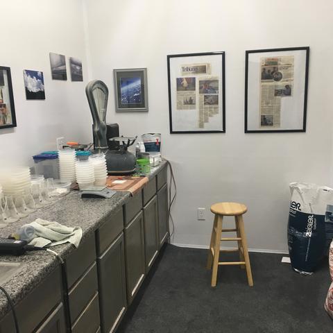 The work room with a steel counter and framed photos